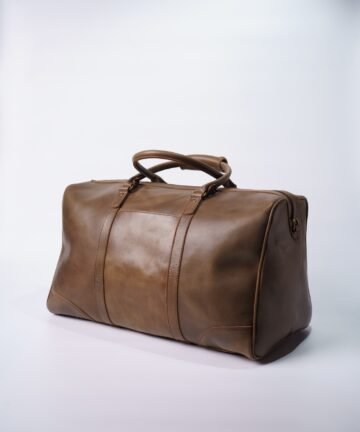 Brown leather travel duffel bag on white background