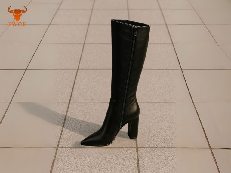 Black knee-high boots with block heels on a tiled floor