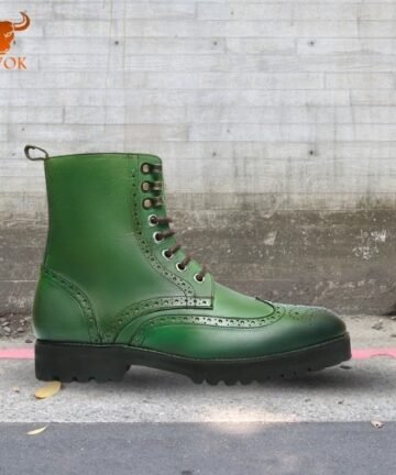 Green leather brogue boots with decorative perforations on pavement