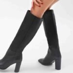 Black long knee-high heeled boots for women with a sleek pointed toe