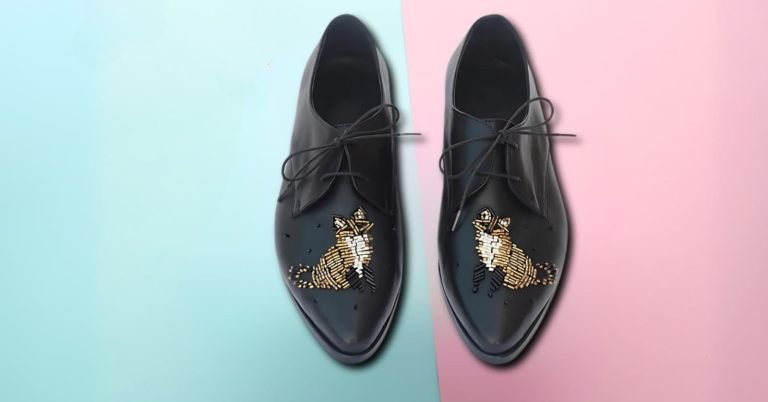 Black women’s leather loafers with gold beaded embroidery on pastel background