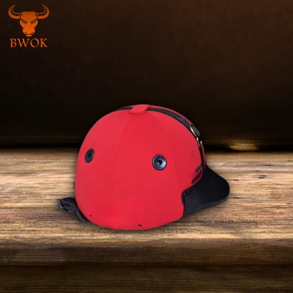 Red equestrian riding cap helmet on wooden table background