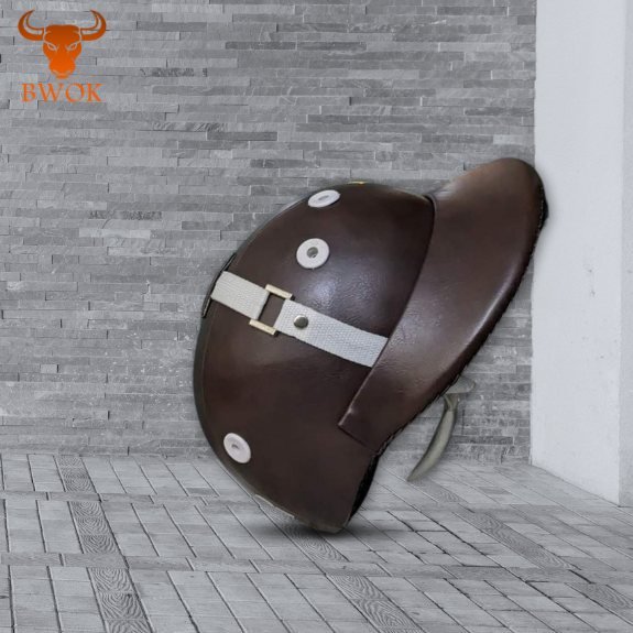 Dark brown horse riding helmet with chin strap on gray tiled background